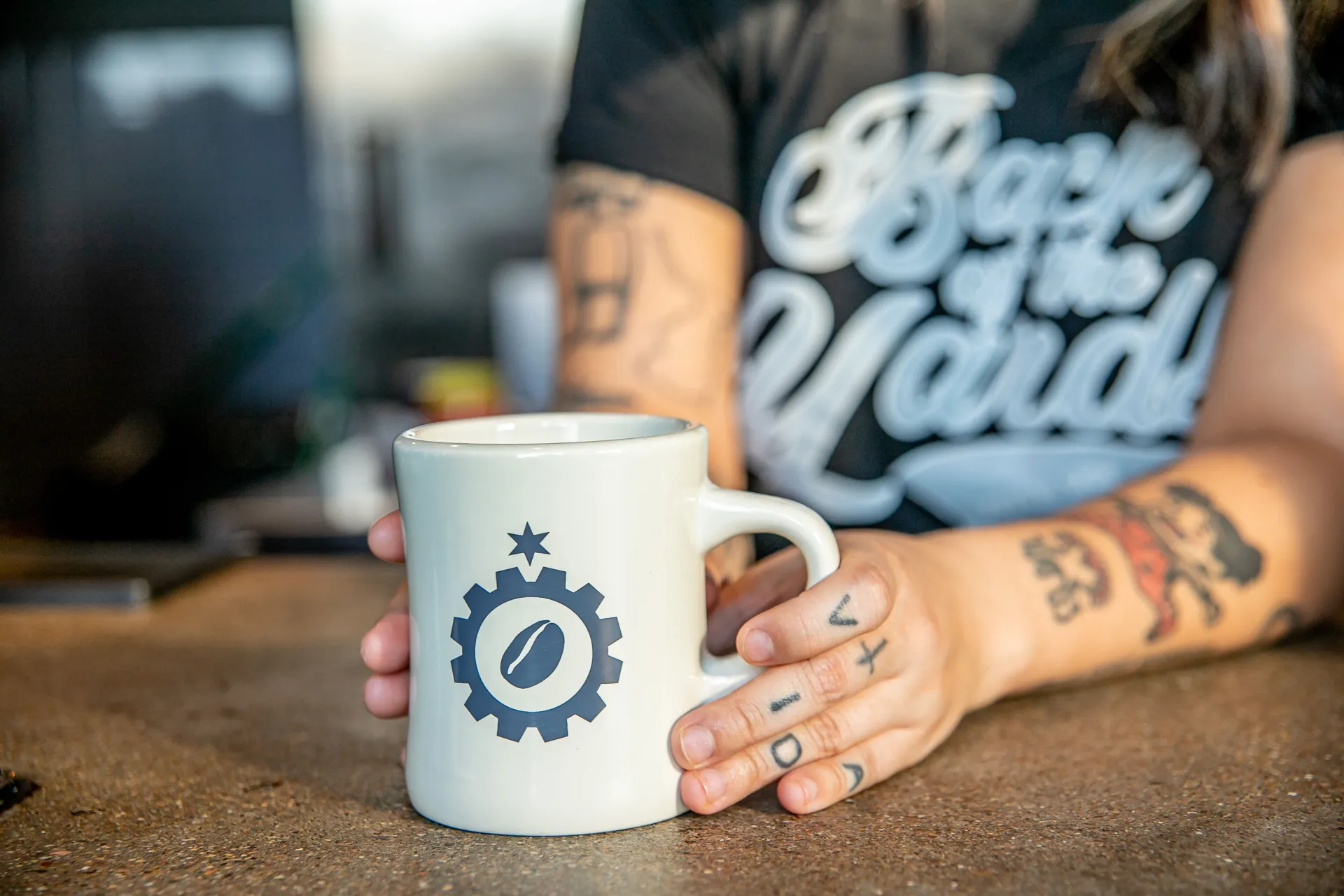 Taza de Back of the Yards con el logo de estrella y engrane sobre la barra