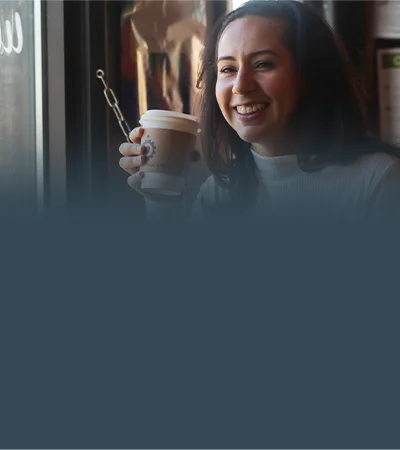 Clienta sonriendo con un café de Back of the Yards